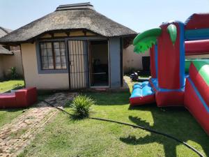 a small house with a slide in the yard at Jamrock Lodge in Winterveld +4 photos