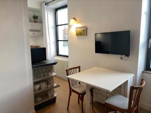 jadalnia ze stołem i telewizorem w obiekcie Studio moderne au cœur de Sauzon avec kitchenette et Wi-Fi - FR-1-418-227 w mieście Sauzon