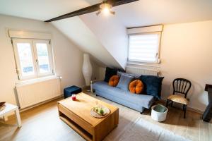 a living room with a blue couch and a table at Le Cosy du Brasseur - Magnifique Duplex Schiltigheim, Proche Strasbourg in Schiltigheim