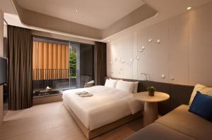 una camera d'albergo con un letto e un divano di 礁溪晶泉丰旅 Wellspring by Silks Jiaoxi a Jiaoxi