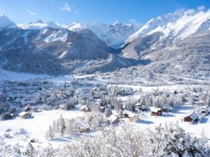 un village recouvert de neige avec des montagnes en arrière-plan dans l'établissement 2 Pièces + Coin Montagne, Cheminée, Parking, Wi-Fi - 4 Pers. - FR-1-762-54, au Monêtier-les-Bains