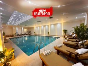 a hotel pool with chairs and a hotel at Paradise Inn Beach Resort in Alexandria