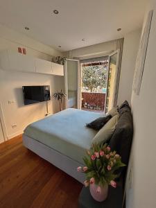 ein Schlafzimmer mit einem Bett und einer Couch und einem Fernseher in der Unterkunft Magnolia 84 Apartment in Florenz