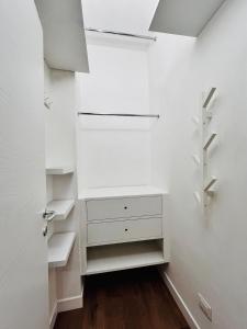 einen begehbaren Kleiderschrank mit weißen Schränken und Regalen in der Unterkunft Magnolia 84 Apartment in Florenz + 17 Fotos