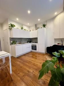 eine Küche mit weißen Schränken und Topfpflanzen in der Unterkunft Magnolia 84 Apartment in Florenz