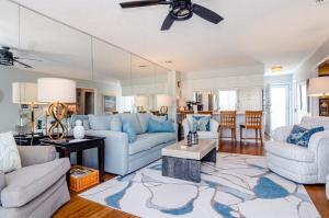 un soggiorno con due divani e un tavolo di Bianchi by Braynt Real Estate a Kure Beach