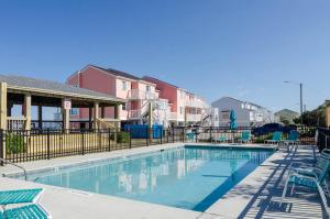 una piscina con sedie e una recinzione di Bianchi by Braynt Real Estate a Kure Beach