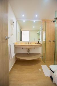 a bathroom with a large sink and a shower at Tamaca Beach Resort in Santa Marta