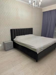 キシナウにあるHeart welcoming park apartmentのベッドとシャンデリアのある寝室