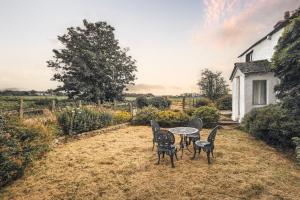 a table and chairs in a yard with a house at The Gilpin Farmhouse, Lake District Getaway in Levens