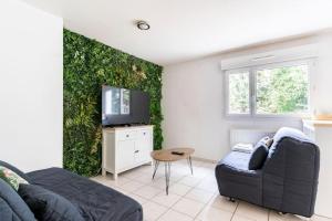 a living room with a couch and a green wall at Geneva Green Studio in Gaillard