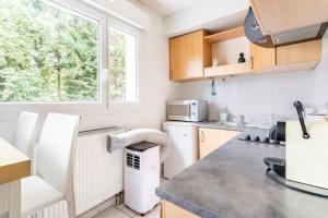 a kitchen with white appliances and a window at Geneva Green Studio in Gaillard +3 photos