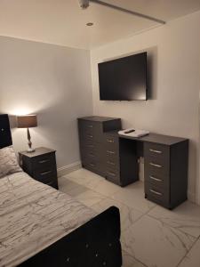 a bedroom with a bed and a desk and a television at Southfield lodge in Middlesbrough