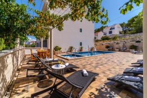 a patio with chairs and a swimming pool at La Perla Apartments 2 in Sutivan