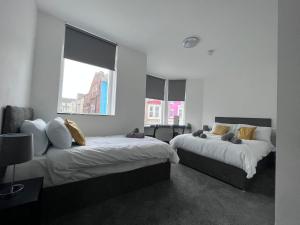 ブラックプールにあるThe White House New York Suitesの窓が2つある部屋にベッドが2つある