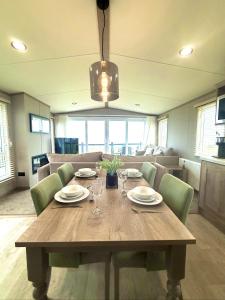 a wooden table with green chairs and a dining room at Skye View Lodge in Filey
