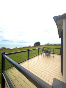 a wooden deck with tables and chairs on a house at Skye View Lodge in Filey