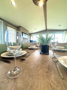 a wooden table with wine glasses on top of it at Skye View Lodge in Filey +81 photos