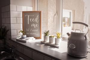 a kitchen counter with plants and a sign that reads feed me till i want no at Central Llandeilo with Stunning views- Sleeps 2 in Llandeilo