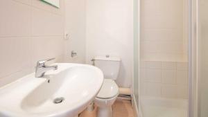 ein weißes Badezimmer mit Waschbecken und Toilette in der Unterkunft Les Ecureuils A N 12 - 3P6 in Saint-Sorlin-dʼArves