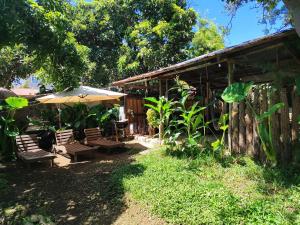 un patio con sillas y una sombrilla junto a un edificio en Posada Maná, en San Juan La Laguna 37 fotos más