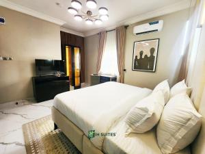 a bedroom with a bed with white sheets and pillows at Ihsuites in Asaba