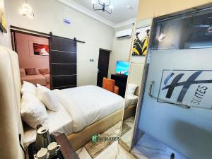 a small room with a bed and a mirror at Ihsuites in Asaba
