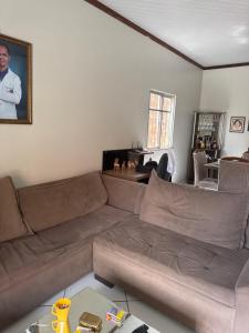 Una sala de estar con un sofá marrón y una mesa. en Casa, en Ananindeua