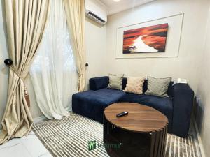 a living room with a blue couch and a table at Ihsuites in Asaba