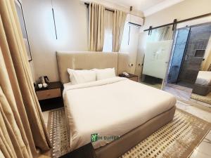 a bedroom with a large white bed and a window at Ihsuites in Asaba