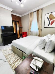 a bedroom with a bed with a phone and a desk at Ihsuites in Asaba