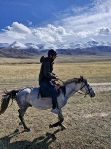 a man riding a horse in a field at Horse riding&Kyzart Homestay in Dzhangyaryk