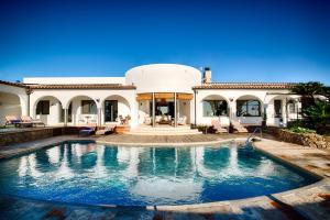 una villa con piscina frente a una casa en Casa de l’Albada, en Roses