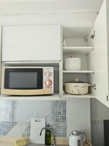 a microwave oven sitting on top of a kitchen counter at Apartment near Central phuket in Phuket Town