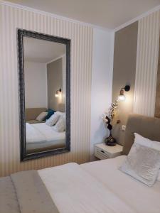 a bedroom with a bed and a mirror on the wall at ALDIRA Studio Arena Nationala in Bucharest