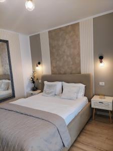 a bedroom with a large white bed with two pillows at ALDIRA Studio Arena Nationala in Bucharest