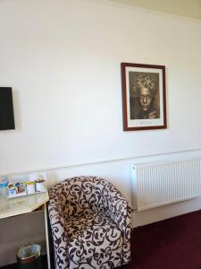 a chair in a room with a picture on the wall at Highfield Guest House in Edinburgh