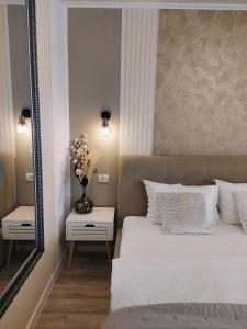 a bedroom with a white bed and a mirror at ALDIRA Studio Arena Nationala in Bucharest