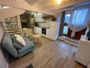 a living room with a couch and a kitchen at Écrin de la baie in Pouldergat
