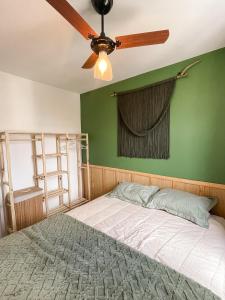 a bedroom with a ceiling fan and a green wall at Tropical apartament in Sao Paulo +21 photos