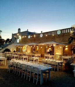 a group of tables and chairs in front of a building at Masseria Fulcignano in Galatone