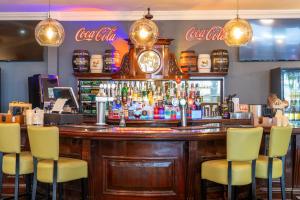 a bar with chairs and a clock on the wall at Sachas Hotel Manchester in Manchester +39 photos