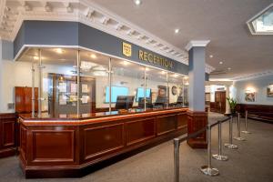 a waiting room with a reception counter in a building at Sachas Hotel Manchester in Manchester