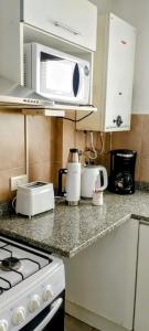 a kitchen with a stove and a microwave at Monoambiente M y L in La Plata +17 photos