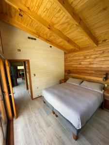 a bedroom with a bed in a wooden cabin at Refugio en Malalcahuello in Malalcahuello