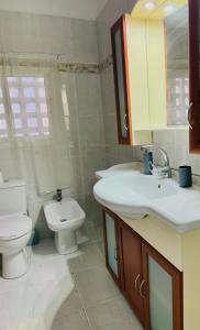 a bathroom with a toilet and a sink at Cozy apartment 3 in Serres +8 photos