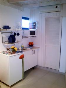 eine Küche mit weißen Schränken und einer weißen Tür in der Unterkunft Punta mujeres casitas del mar in Arrieta + 2 Fotos