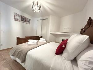a bedroom with a large white bed with red pillows at Le Chavanna - Terrasse Parking - CLG Savoie in Saint-Pierre-dʼAlbigny