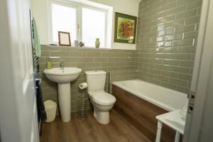 a bathroom with a toilet and a sink and a tub at Family friendly, sleeps 5, 3 mins to beach in Deal +12 photos