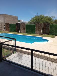 ein Schwimmbad mit einem Zaun um ihn herum in der Unterkunft CASA quinta ""LUZ AZUL"" con pileta, galeria, calefaccion , doble aire frío calor, WIFI in Santa Rosa